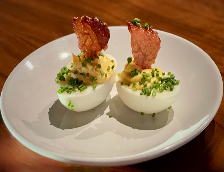 deviled eggs with chopped onions and garnish